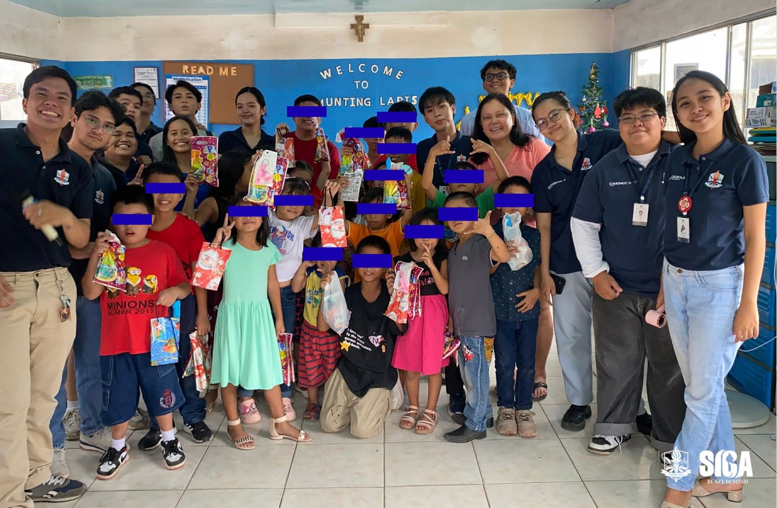 Children and student volunteers gather for a group photo